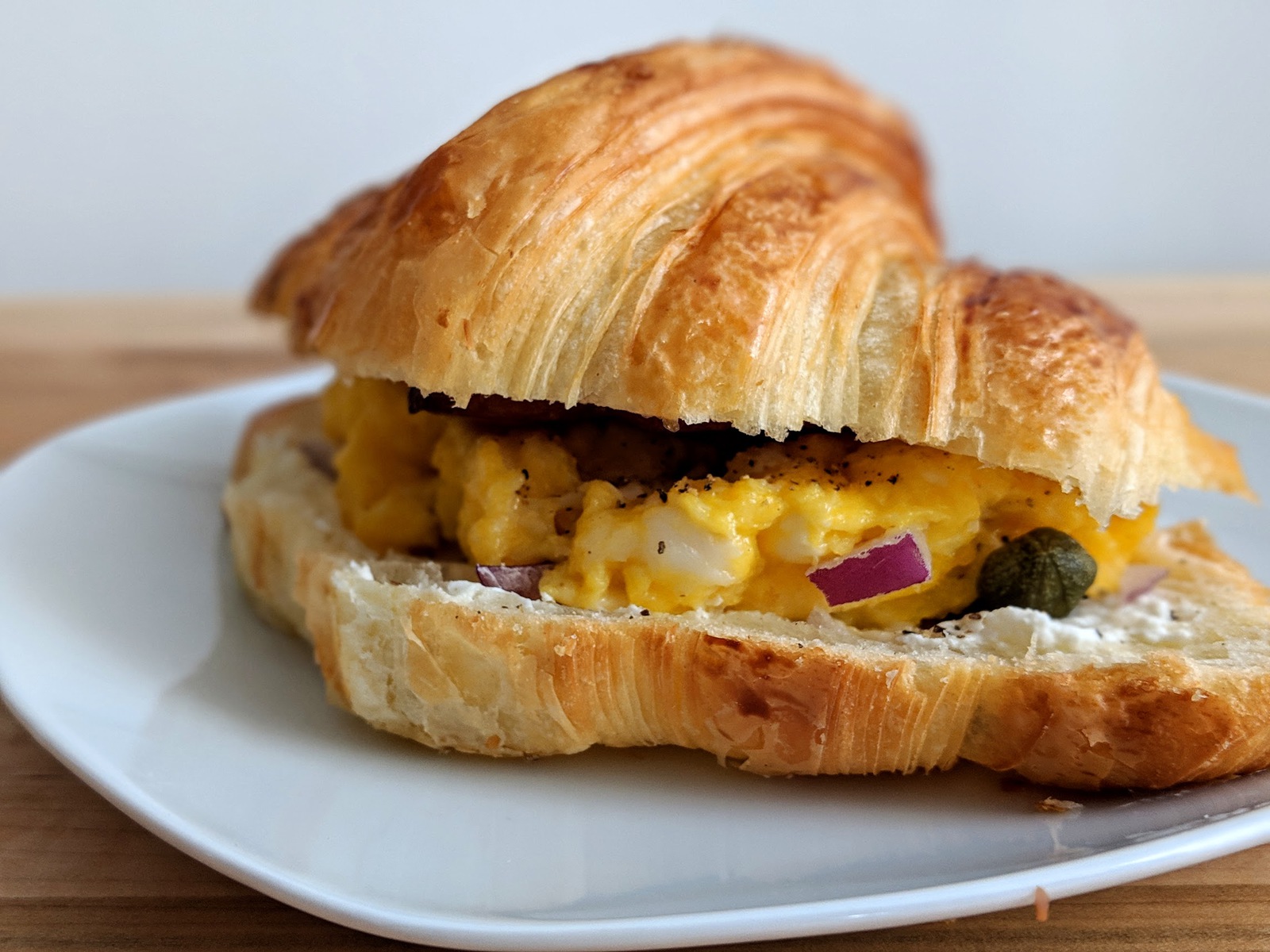 Croissant breakfast sandwich with bacon and eggs
